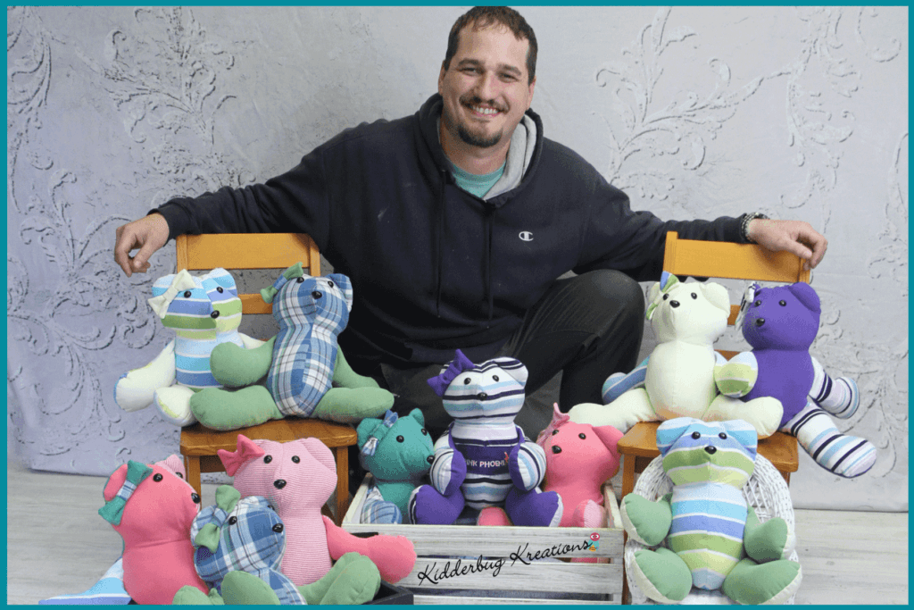 Man surrounded by multiple memory bears made by Kidderbug Kreations from shirts after the loss of his mother.